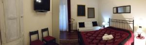 sala de estar con sofá rojo y TV en B&B Le Muse, en Trento