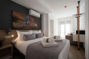 a bedroom with a large bed and a couch at Luxor Torre del Clavero Apartments in Salamanca