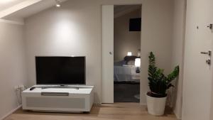 una sala de estar con TV en un armario blanco en Le Cadran Solaire - Nel cuore di Aosta, en Aosta