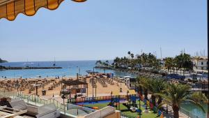 a view of a beach with a pool and a resort at HD Mogan Beach Apartment in Puerto de Mogán
