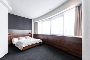 Un pat sau paturi într-o cameră la Tempus Club Garni Hotel