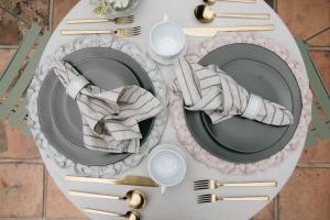 a table with plates and utensils on a table at Nima Local House Hotel & Spa in Mexico City