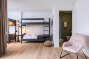 una camera con 2 letti a castello e una sedia di Magma Hostel a Ponta Delgada