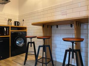 a kitchen with two bar stools and a washing machine at Queen Street Boutique Suites in Edinburgh +45 photos