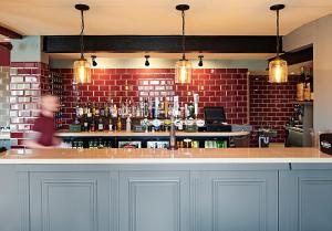 um bar com uma pessoa a andar atrás de um balcão em The Frampton Arms em Dorchester