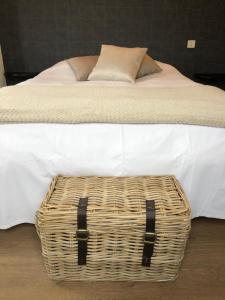 Una cama con una cesta de mimbre encima. en Hotel du Pot d'Etain en Châlons-en-Champagne