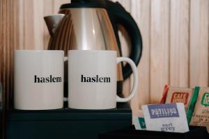 a coffee cup and a mug on a table at Haslem Hotel in Lisburn