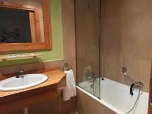 uma casa de banho com um lavatório e uma banheira em hotel gueñes em Güeñes