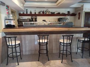 a bar in a kitchen with three bar stools at hotel gueñes in Güeñes