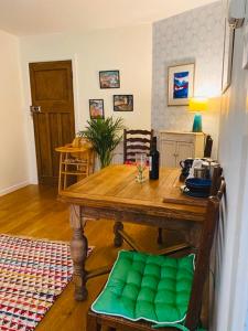 un tavolo in legno con un sedile verde in una stanza di Vinegar Hill Pottery a Lymington