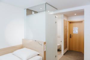 a small bedroom with a bed and a bathroom at Sankt Magdalena in Linz