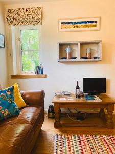 un soggiorno con divano e tavolo con computer di Vinegar Hill Pottery a Lymington