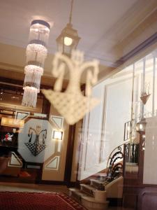 a lobby with a chandelier and stairs in a building at Hôtel Juana in Juan-les-Pins
