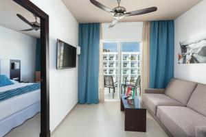 a hotel room with a bed and a couch at Hotel Riu Costa del Sol - All Inclusive in Torremolinos
