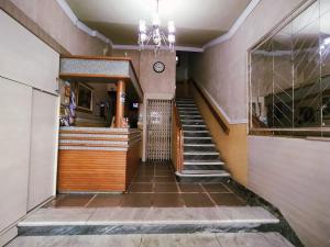 un couloir dans un immeuble avec des escaliers et une horloge dans l'établissement Palace Hotel, à Curitiba