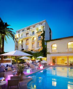 a hotel with a swimming pool in front of a building at Hôtel Juana in Juan-les-Pins