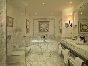 a bathroom with two sinks and a tub and a shower at Rocco Forte Hotel Savoy in Florence