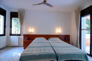 a bedroom with a bed and a ceiling fan at MAS TOMASI 525 A in Pals