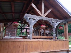 a wooden pavilion with a table and potted plants at Cabana Logolda in Cavnic