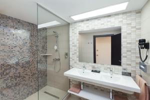 a bathroom with a sink and a shower and a mirror at Hotel Riu Costa del Sol - All Inclusive in Torremolinos