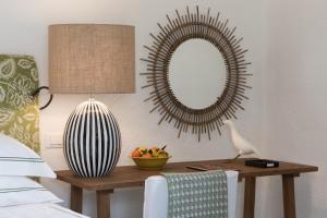 a bedroom with a table with a mirror and a chair at Rocco Forte Masseria Torre Maizza in Savelletri di Fasano