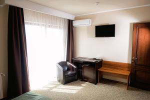 a hotel room with a desk and a chair at Curtea Bizantina in Suceava