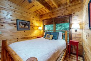 ein Schlafzimmer mit einem Bett in einer Blockhütte in der Unterkunft Mi casa es su Casa in Blue Ridge