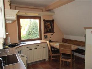 uma pequena cozinha com uma mesa e uma janela em Ferienwohnung am Wasserturm em Hohen Neuendorf
