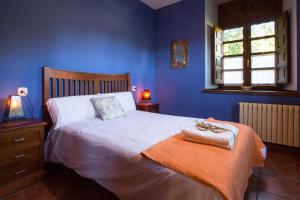 um quarto azul com uma cama com duas toalhas em El Balcón De Muniellos em Oballo