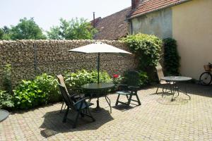 un patio con mesas, sillas y una sombrilla en PENSIUNEA MURY, en Brasov