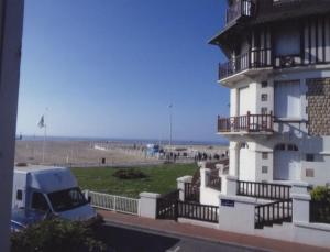 un camion parcheggiato vicino a un faro vicino a una spiaggia di Au Soleil Couchant a Trouville-sur-Mer