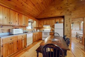 una cucina con armadi in legno e un tavolo in una cabina di Cabin Sweet Cabin a Blue Ridge