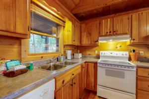 una cucina con armadi in legno e un piano cottura bianco con forno di Cabin Sweet Cabin a Blue Ridge