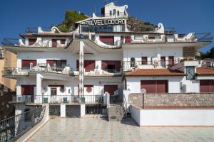 een groot wit gebouw met balkons op een heuvel bij Hotel Vello d'Oro in Taormina