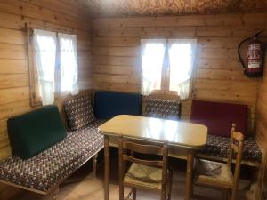 a dining room with a table and chairs at Bungalós Las Nieves in Puebla de Lillo +3 photos