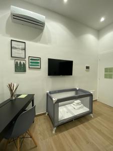a living room with a bed and a flat screen tv at Solli Bed & Breakfast in Palermo