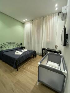 1 dormitorio con 1 cama, 1 silla y TV en Solli Rooms, en Palermo