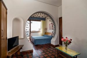 una camera con letto e un arco in una stanza di Hotel Vello d'Oro a Taormina