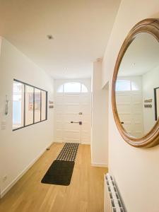 a hallway with a round mirror and a door at APT bord de Mer, hypercentre Dinard, Parking prive in Dinard