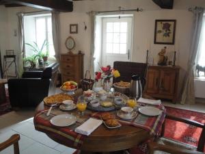 a table with food and drinks on it in a living room at Maison Vérosia in Saint-Loup-de Naud