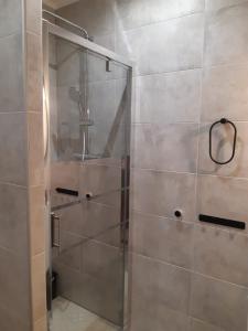 La salle de bains est pourvue d'une douche avec une porte en verre. dans l'établissement Le Mas Mérindol Gîte Ventoux, à Loriol-du-Comtat