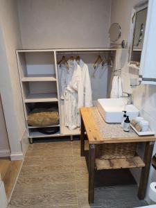 a bathroom with a sink and a cabinet with white robes at Shepherd's Cottage in Nieu-Bethesda +22 photos