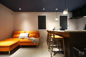 an orange couch in a kitchen with a bar at Real Life AOYAMA in Tokyo