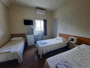 מיטה או מיטות בחדר ב-Hotel Três Passos - Prox ao Aeroporto e Rodoviária