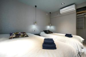 sypialnia z 2 łóżkami i ręcznikami w obiekcie Real Life AOYAMA w Tokio