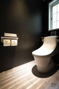 Real Life AOYAMA في طوكيو: حمام مع مرحاض أبيض في جدار أسود