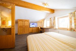 a bedroom with a bed and a sink and a tv at Haus Rosmarie in Sankt Anton am Arlberg