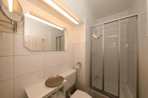 a white bathroom with a toilet and a mirror at Hotel Am Ehrenhof in Düsseldorf +46 photos