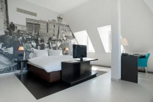 a living room with a bed, desk and a television at Inntel Hotels Amsterdam Zaandam in Zaandam