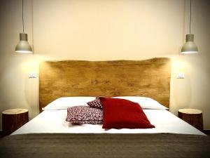 a bed with a red blanket and two pillows on it at B&B Il Vicolo in Caprarola